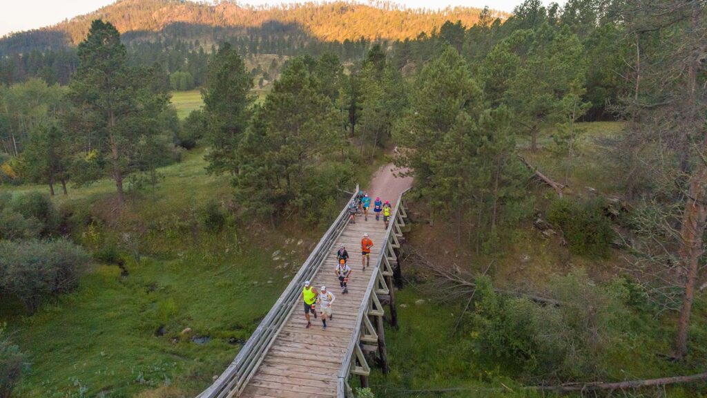 Runners crossing a wooden bridge on the Mickelson Trail