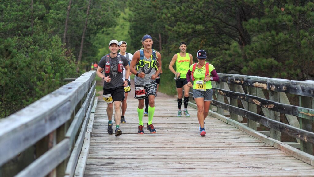 Runners crossing a wooden bridge